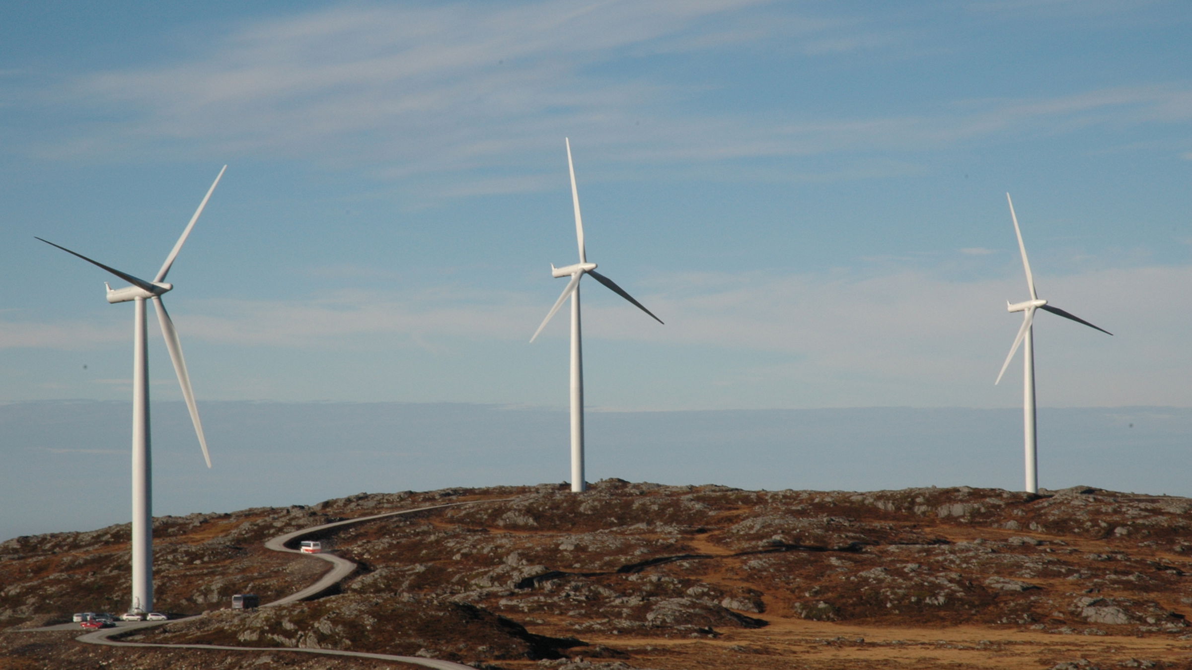 Three wind turbines on top of a mountain